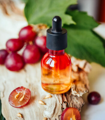 Grape seed oil. Still life of bottle with oil, and grape seed on the natural background. Grape seed oil. Still life of bottle with oil, and grape seed on the natural background