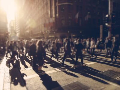 Crowd of people walking over the crosswalk at sunset. Sydney, Australia